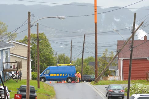 A Newfoundland Power employee places a pylon on Caribou Road in Corner Brook, near where a utility pole cracked and was leaning dangerously Sunday afternoon.
