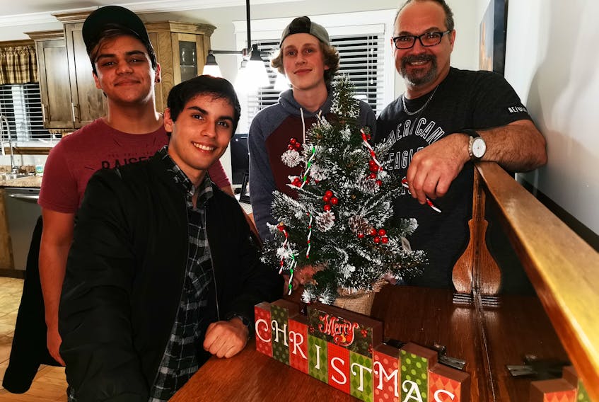 Exchange students, from left, Victor Fioretti and Erick Souza of Brazil, and Jannis Kamp, Germany, will be spending Christmas with host dad Darin Boone in Grand Falls-Windsor, taking in his traditions, as well as some from Newfoundland. KRYSTA CARROLL/SPECIAL TO THE CENTRAL VOICE