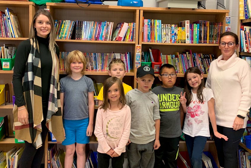 Grade 1 teacher Alicia Power, left, and Cloud River Academy librarian Sonya Randell-Cull, right, with some of the Grade 1-3 students at the school library. These children will be among those who will benefit from donations to the library. CONTRIBUTED