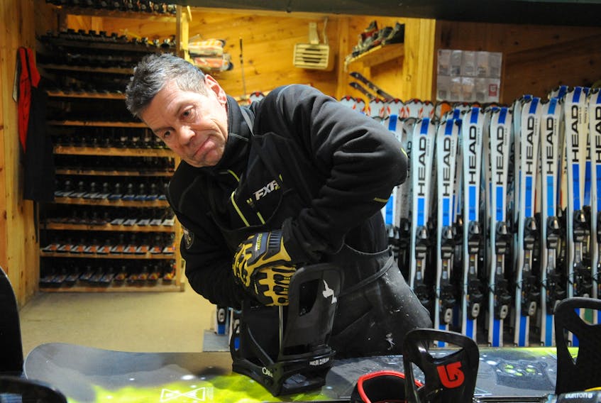 Don Miller switches out snowboard bindings in the rental and repair shop at Marble Mountain. On New Year's Eve, he was busy preparing for the season, sanding and waxing snowboards and skis. STEPHEN ROBERTS /THE WESTERN STAR