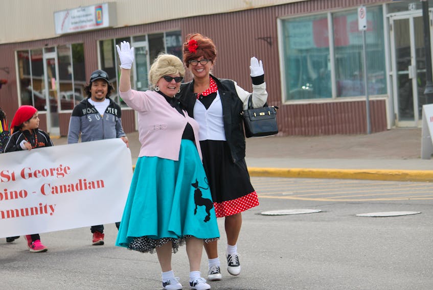 These two friendly ladies, Cecilia Lawrence, left and her sister Mary Tompkins with big hair and dressed in 50’s garb, were amongst the many who took part in the parade on Wednesday evening to kick off Friendly Invasion events in Stephenville taking place through July and August. Behind them are some of the people from the Bay St. George Filipino – Canadian Community. FRANK GALE/ THE WESTERN STAR