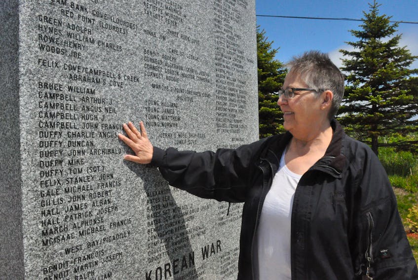 Stella Cornect poses for a photo touching the area of the Second World War monument that bears her dad’s (Charlie Angus Duffy) name at the Veterans’ Memorial Square in Cape St. George. FRANK GALE/ THE WESTERN STAR