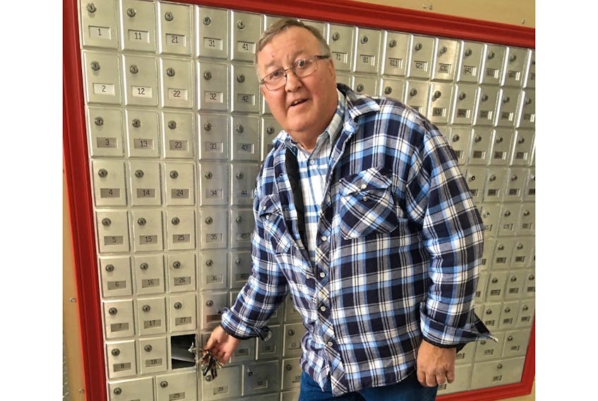 Eddy Billard opens his mailbox in the Grand Bay post office’s new location. The post office location recently moved from a residential area of Grand Bay East to the A-1 Liquidations business in Grand Bay West. CONTRIBUTED BY JOAN CHAISSON