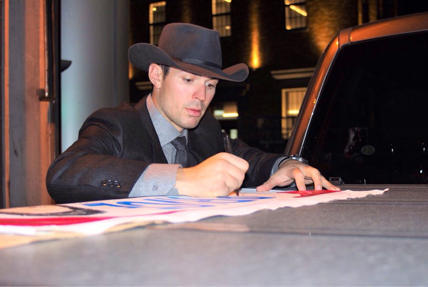 Montreal Canadiens goalie Carey Price signs a picture of himself painted by Brad Penney of Mount Moriah. Penney took the painting to game in Montreal Oct. 10 and managed to meet up with Carey outside a parking garage. CONTRIBUTED BY ERNEST GREEN
