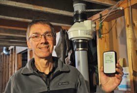 Bill Alexander poses for a photo in his basement holding his radon detector device with his radon sub-floor depressurizing fan and part of the venting system seen behind him. FRANK GALE/ THE WESTERN STAR
