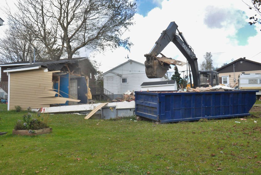 The house at 17 King Street in Stephenville, when there were more than 80 cats removed, is seen being demolished by an excavator last Thursday.