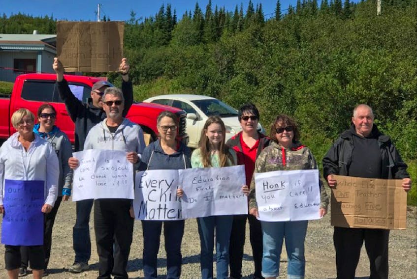 Protestors at Basque Memorial Academy in Red Bay hold signs questioning the decision to cut back the number of teachers at the school to one and to remove French from the school’s curriculum.