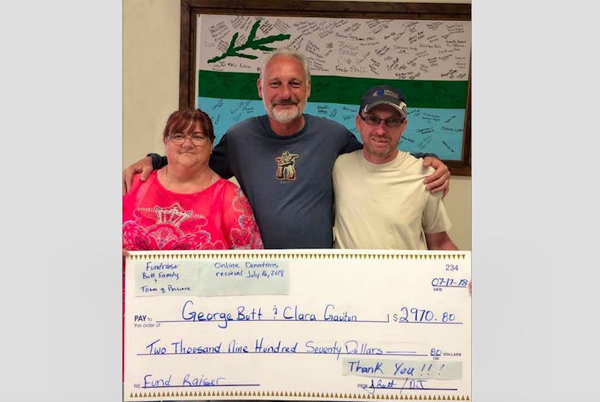 Clara Gaulton (left) and George Butt (right) were presented a $2,970 cheque from Pinware mayor Didier Naulleau (centre). Naulleau started a Facebook fundraiser for the family after their home burnt down in June.