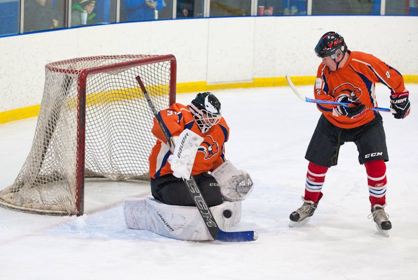 Rob Roberts makes the save for the Northeast Sabres during Sunday’s Central Senior Intermediate Hockey League action against the Springdale Braves. Teammate Paul McDonald stands by to make sure the rebound is cleared away.
