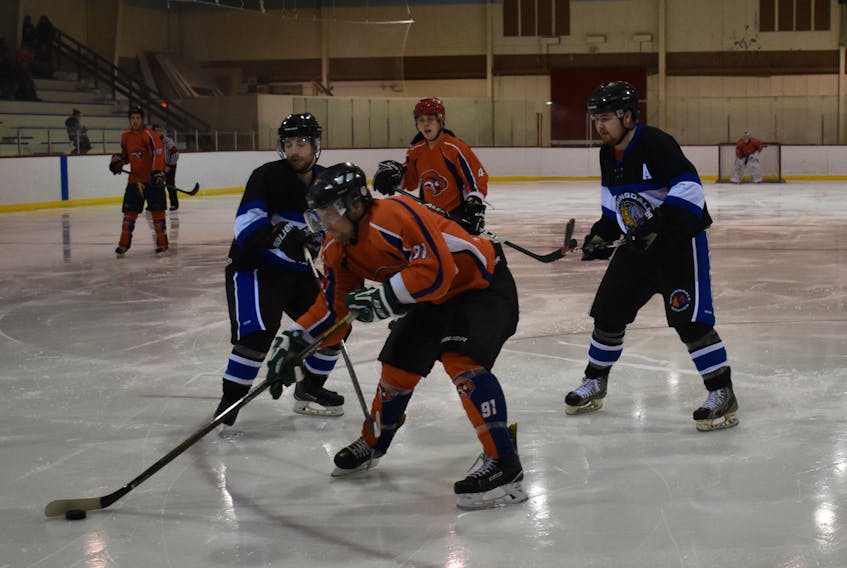 P.J. Budgell of the Northeast Sabres controls the puck, with Alex Goudie and Jeremy Drover of the Springdale Braves in close pursuit during weekend action in the Central Senior Intermediate Hockey League.