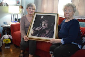 (From left) Joanne Shepard and her mother Theresa Young hold a of photo of Fabian “Fabe” Young, Shepard’s father and Young’s husband. Fabe was one of 10 miners who died during the explosion inside No. 26 colliery in Glace Bay on Feb. 24, 1979. Two other miners died later in hospital and four survived. The photo of Fabian was taken by Warren Gordon who gave the family a copy of it.