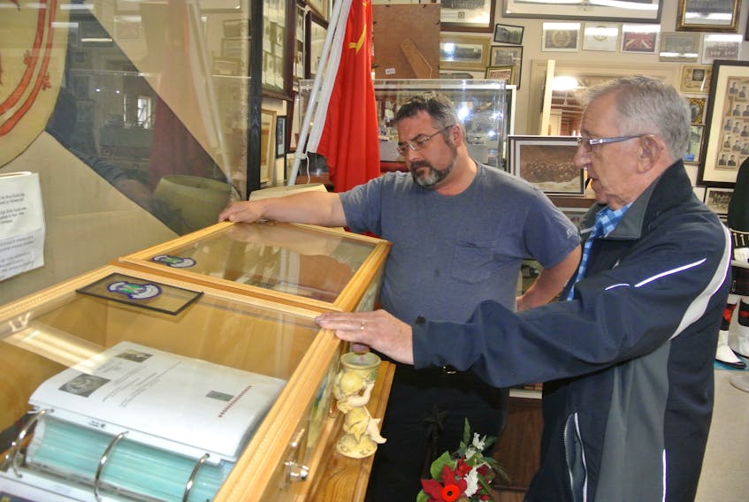 North Nova Scotia Highlanders Regimental Museum assistant curator John Wales (left) and curator Ray Coulson look over the museum’s memory book that lists the names and biographies of each of the members of the unit that were killed during the Second World War.