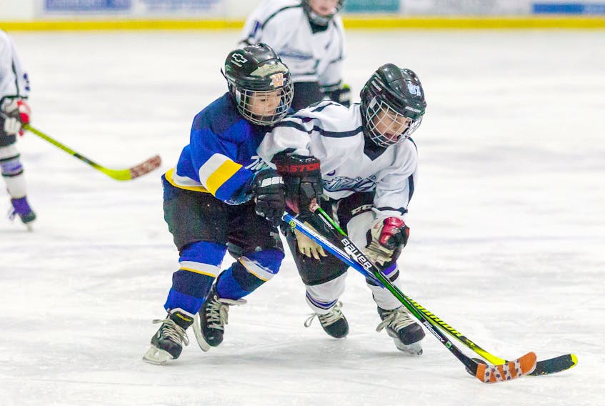 Austin Duguay of the Cumberland County Kent Ramblers battles with a Brooklyn player in recent novice advance play at the Amherst Stadium. The Kent Ramblers are hosting the novice advance Bluenose tournament at the Amherst Stadium and Richard Calder Arena in Springhill.
