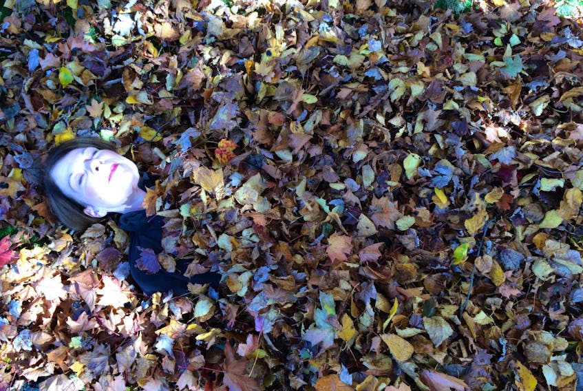 Last Sunday, when I asked my friend Allie to bury me in the leaves we had been raking, I didn't expect the photo to turn out quite like this.  Bright sunlight filtering through a small opening in the leaves on the tree turned my rosy cheeks to a cold, bloodless blue.