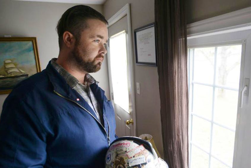 John Holmes holds his old hard hat at his Murray Harbour home. Holmes wants to raise awareness about mental health and career retraining supports offered in P.E.I. to former oil patch workers struggling after the industry’s decline.