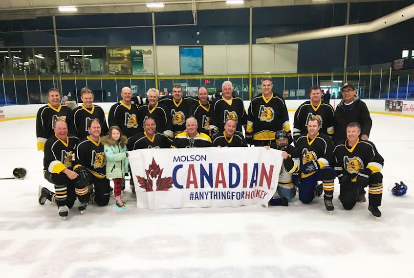 The Antigonish Old Dogs who participated in the Molson Canadian Moncton Dynomites Tournament March 29-31. Pictured is Allan MacDonald (back, left), Paul Bourque, Rob Dunphy, Deiter Haas, Kevin Cameron, Gary Wood, Allie MacDonald, Donnie MacDougall, Brent MacDougall, coach Greg MacDonald, Greg MacDonald (front, left), Adam Dunphy with daughter Addison, Stephen MacKenzie, Doug Vail, Richard MacKenzie, trainer Mark from Moncton, Willie Joe Sofan and Leonard MacEachern. The Old Dogs won their division at the tournament; the seventh time in a row they have, with different line-ups, claimed a tournament title.