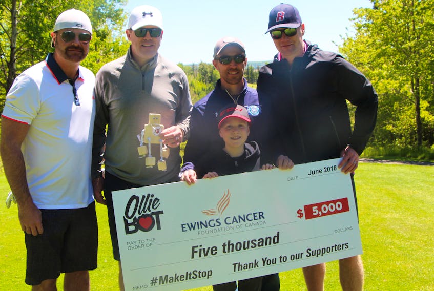 The Bonvie-MacDonald Rinks to Links Golf Classic supported the Smith family’s donation to Ewings Cancer Foundation of Canada, through their Olliebot work, with this year’s event. Pictured during the golf portion of the Classic, June 15 at Antigonish Golf and Country Club, are IMP Solutions Dave Power (left) who made a significant purchase during the auction and then donated it to the Smith family, event co-founder Craig MacDonald holding special Olliebot with a Harvard logo given to him by the Smiths, dad Bryan Smith, event celebrity Gord Dwyer and, out front, young Oliver Smith whose battle with cancer last year led to the creation of the Olliebots and the generous donation to the foundation.