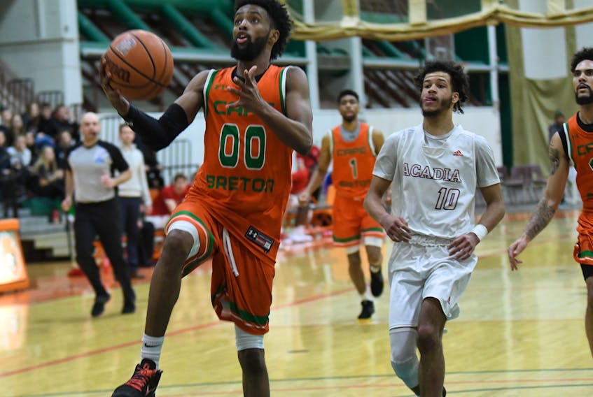 Cape Breton's Osman Omar drives to the hoop while being pursued by Acadia's Marcus Upshaw in the final minute of the Capers' 75-67 victory over the Axemen at CBU's Sullivan Fieldhouse. The Capers men won both games of a weekend series against Acadia to clinch a berth in the upcoming AUS championships, Feb. 28 through March 1 at the Scotiabank Centre in Halifax. The women Capers split their weekend series with Acadia. They are also qualified for the AUS championship tournament.