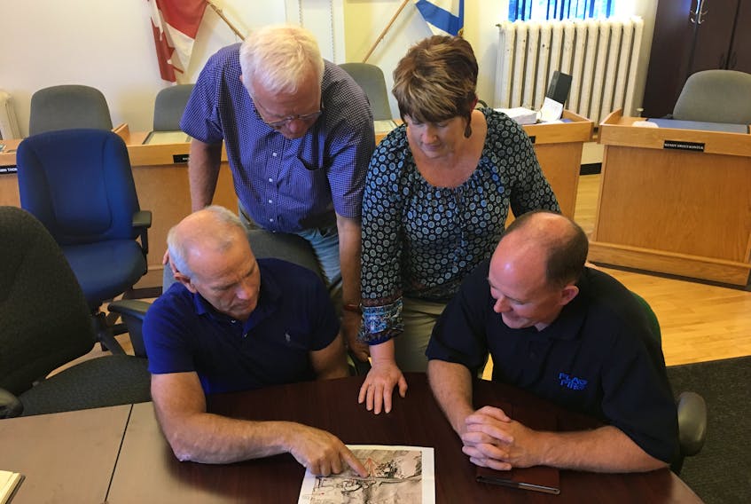 Cumberland EMO co-ordinator Mike Johnson (seated left) and Cumberland South MLA Tory Rushton (seated right) look over a photo of a LIDAR image of the Oxford area showing sinkholes with Cumberland-Colchester MP Bill Casey and Oxford CAO Rachel Jones. They are urging the province to reconsider its decision not to conduct a study of the Trans-Canada Highway to ensure there is no potential for sinkhole development there.