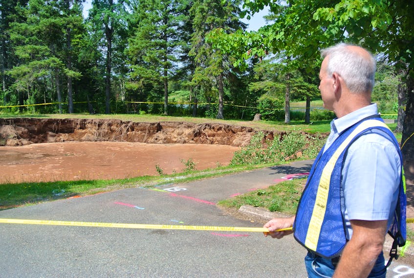 Mike Johnson, Cumberland County’s EMO coordinator, looks over the sinkhole in the Oxford Lions Park following a media briefing on Tuesday.