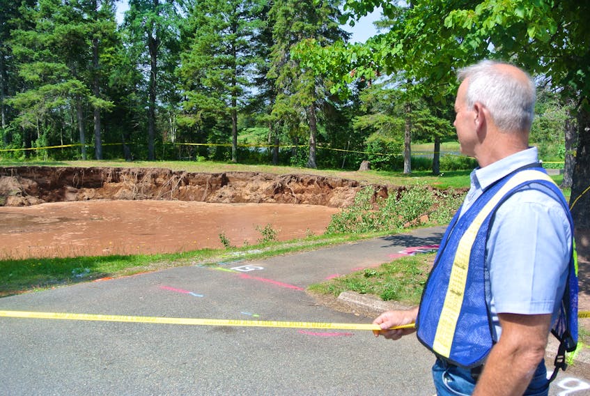 Cumberland EMO co-ordinator Mike Johnson looks over Oxford’s sinkhole last August. The results of geophysical testing by GHD Ltd. are expected to be finalized by the end of July and should be released to stakeholders and then the public sometime in August. File