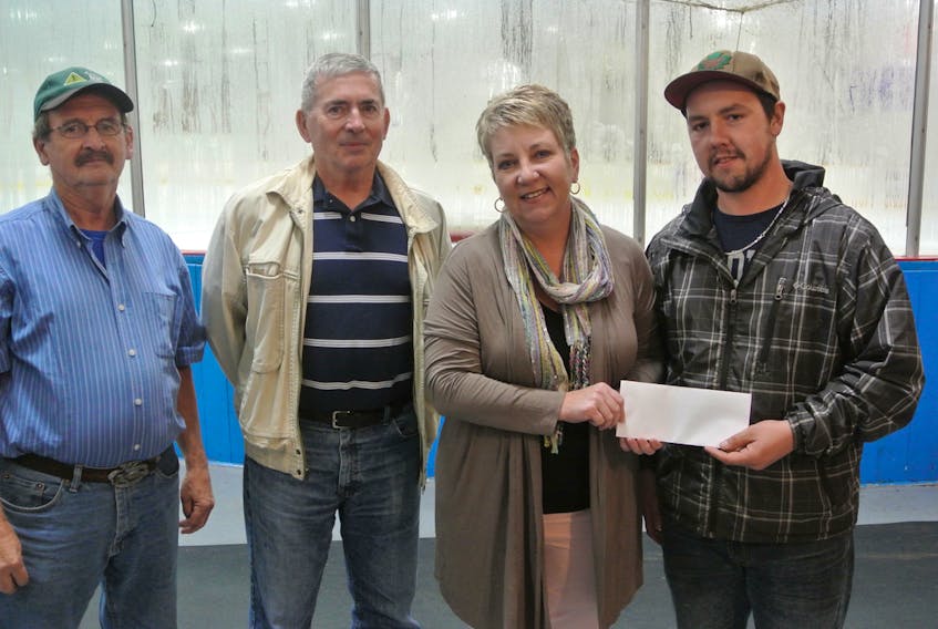 Cole Wood of the Oxford Arena committee presents a $7,500 cheque to Oxford Mayor Trish Stewart while committee members and Oxford town councilors Brenton Colborne and Tom Kay look on.