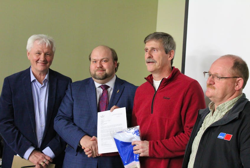 From left to right, Minister of Municipal Affairs and Environment Eddie Joyce, MHA Neil King, LSD chair Craig Pardy, and Morgan Ellis.  King hands Pardy the official letter of approval and a provincial flag.