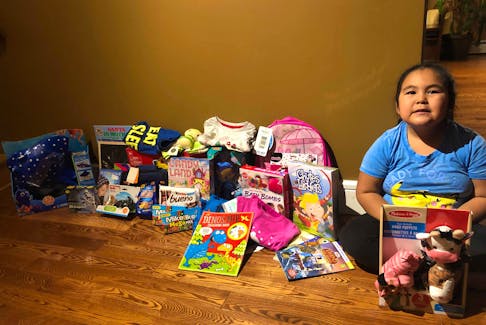 Six-year old Olivia Legge with toys collected for Matthew,7, and Rachel,2.