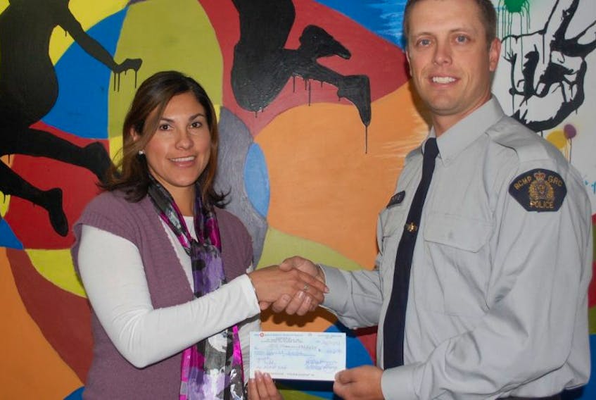 Const. Jarrett Thorne presents Youth Tube executive director Roxana Green with a cheque for $3,500.