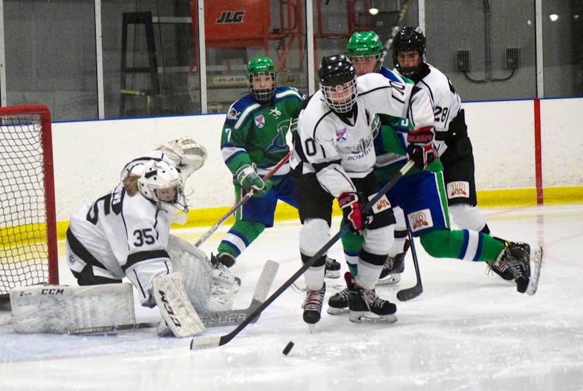 Pictou County Major Bantam Bombers’ goaltender Jorja Burrows makes a save as Brendan Avery moves to clear the puck in a game on Dec. 1 against the Dartmouth Whalers.