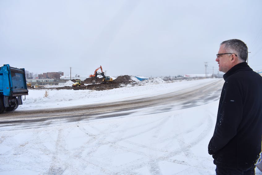 Andy Thompson, director of New Scotland Business Development Inc. and councillor for the Municipality of Pictou County watches work underway on a lot that recently sold in New Glasgow.