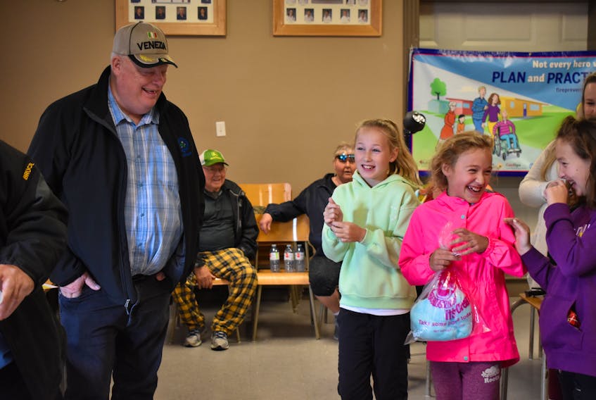 Pict municipality councillor Peter Boyles with Frank H MacDonald Elementary students, Annika Felderhof and Rylan Grace. Both Felderhof and Grace won a drive to school in a fire truck courtesy of the Linacy Fire Department.