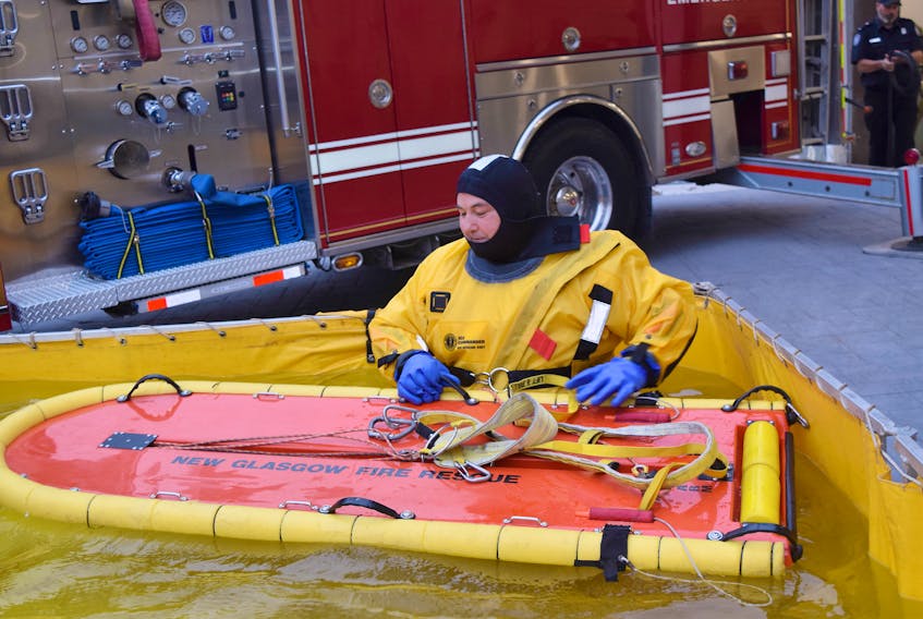 John LeBlanc of the New Glasgow Fire Department, displays a rescue board while wearing an all-weather water/ice rescue suit.