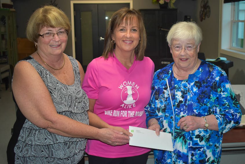 Cathy Cotter, left, of the Women Alike Society, accepts a cheque from Terri Arbuckle, middle, of funds raised from this year’s Bike Run for the Boobies. At right is Arbuckle’s mother Beverly McGuigan.