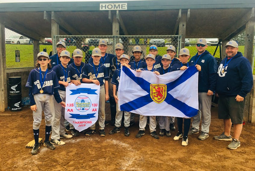 The New Glasgow U13 DQ Blizzards lift the banner. In front from left are: Landon Steele, Robert Hollis, Harley Clarke, Maddux MacKenzie, Corbin MacDonnell, Ethan MacKay, Derrick MacKay and Wyatt Spence. In back are: assistant coach Casey Spence, Ayden Brezinski, Issac Haines, Keinon Bourque-Decoste, Marshall Brown, Lachie MacDonald, head coach Bill MacKenzie and assistant coach Freddy MacKay.