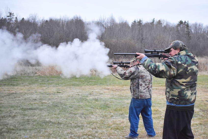 James Agnew, front, and his father Fraser Agnew fire muzzle loaded guns at a rifle range in Pictou County.