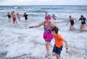Robin Roy and her grandson Teigan rush out of the water at Melmerby after taking part in a polar bear swim to start 2021.