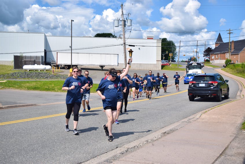 Aaron Smith brings the torch home Industries following the Michelin-Law Enforcement Torch Run, held July 10 through parts of Pictou County.