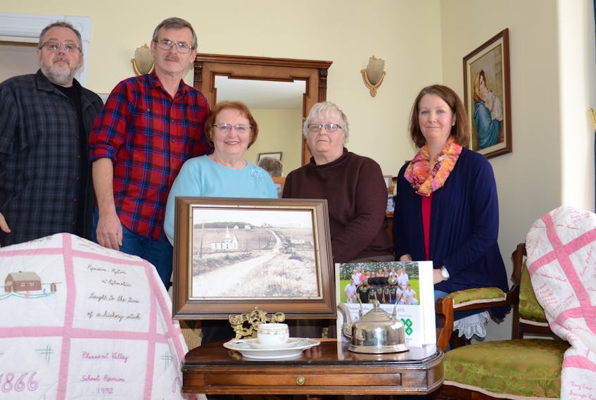Committee members show some of the artifacts mentioned in their new book, “Pleasant Valley: Our Community History and Stories” which will be launched Sunday, Nov. 17, 2 p.m., at Pleasant Valley Memorial Church. From left are Carter Jeffery, project co-ordinator, Arnold Smith, Carol MacLellan, Louise Weeks and Verna Lynne Weeks. Pictured, from left, are the Pleasant Valley School history quilt, 1992, Pleasant Valley hollow, 1913, Murray family china tea set, Pleasant Valley 4-H history photo book, McLennan teapot 1902 and the Pleasant Valley United Church signature quilt, 1957. STACY MACINNIS/Special to The Guardian