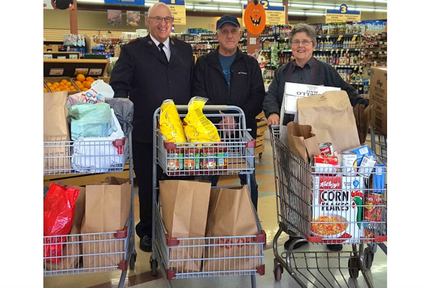 Volunteer Robert Arsenault, left, and Major Wayne Green of the Salvation Army were at the Wellington Co-op on Oct. 25 with employee Angèle Arsenault.