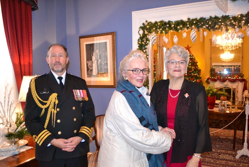 Lt.- Gov. Antoinette Perry welcomes Barb Rhodenhizer to the Christmas open house at her official residence, Fanningbank, on Tuesday. Rhodenhizer was one of many people who toured the historic home in Charlottetown's Victoria Park, which was dressed in its festive finery. Visitors also had to chance to listen to songs by the Canada Remembers chorus. At the right is Cmdr. Rob Alain, aide-de-camp. Another open house will be held today, 1-3 p.m.
