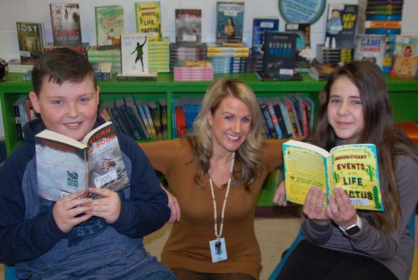 Ashley Bell, a Grade 7 teacher at East Wiltshire Intermediate School, poses with her students, Olivia MacDougall and Auston Potts. Grade 7 libraries across P.E.I. are being set up to provide all grades 7-12 students daily access to high-quality literature in their classrooms.