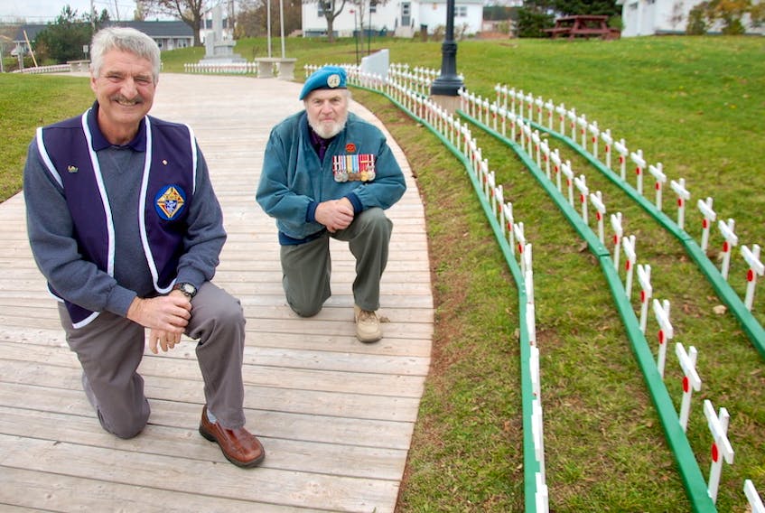 James Donnelly, grand knight of the Knights of Columbus (K of C) Father McNeill Council 9025, left, and K of C member Simon Lemay pose by the impressive display of wooden crosses that pay tribute to 420 late veterans buried in the North Rustico area.