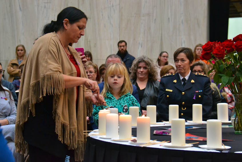 Mi’kmaq Elder Julie Pellissier-Lush lights a candle during an event in Charlottetown commemorating the Dec. 6, 1989, murder of 14 women at École Polytechnique in Montreal. The event also commemorated 10 women who have been murdered on P.E.I. since 1989. - Stu Neatby