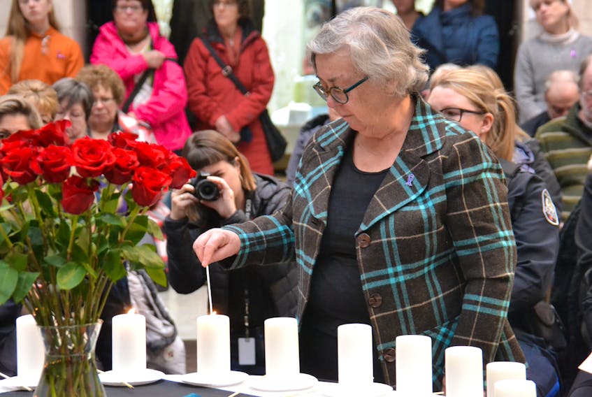 Ann Sherman, outgoing chairwoman of the Premier's Action Committee on Family Violence Prevention, lights a candle during an event in Charlottetown commemorating the Dec. 6, 1989 murder of 14 women at École Polytechnique in Montreal. The event also commemorated 10 women who have been murdered on P.E.I. since 1989. - Stu Neatby
