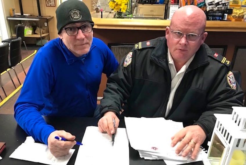 Peter MacDonald, left, and Winston Bryan, co-chairmen of the Canadian Firefighters Curling Championship, go over plans for the national event. The rescheduled championships are now set for March 24-April 2, 2022, in Montague.