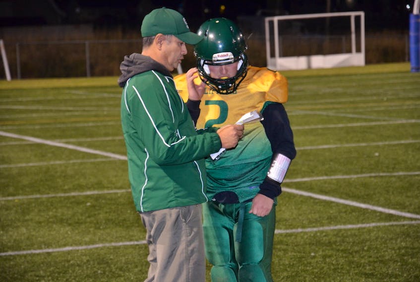 Summerside Clippers head coach John Turner discusses strategy with quarterback Nic Gunning during a P.E.I. Varsity Tackle Football League game at Eric Johnston Field during the 2019 season.