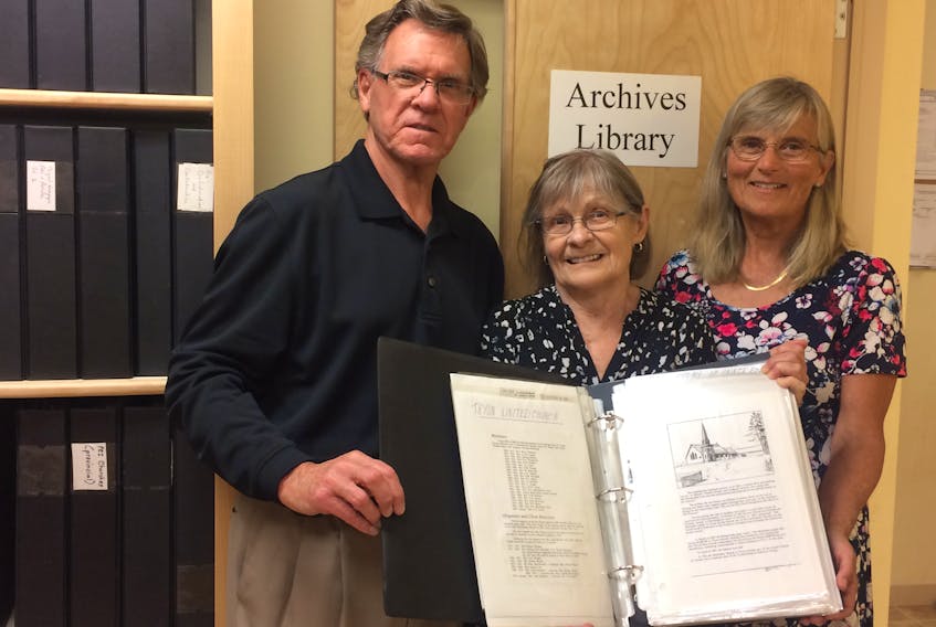 Jack Sorensen, left, Lorna Lord and Fran Albrecht, members of the South Shore Archival Committee, show a completed copy of one of the books catalogued from the William Waddell Historical Collection.