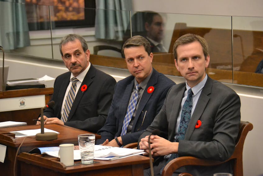 Environment, Water and Climate Change Minister Brad Trivers, centre, along with Todd Dupuis, executive director of climate change and the environment, and Brad Colwill, deputy minister of environment, water and climate change, take questions during a standing committee meeting on Thursday.