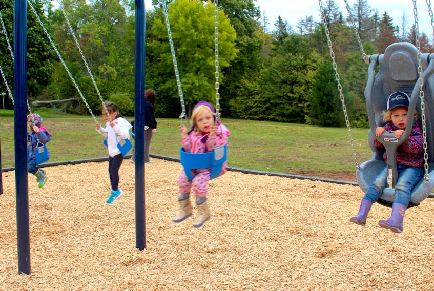 Anthea Greer, right, and Brielle Larter swing at the Cornwall park on McCarthur Drive, using the new accessible swing built under the accessibility lens program established by the P.E.I. Council of People with Disabilities to create spaces that serve different types of people.